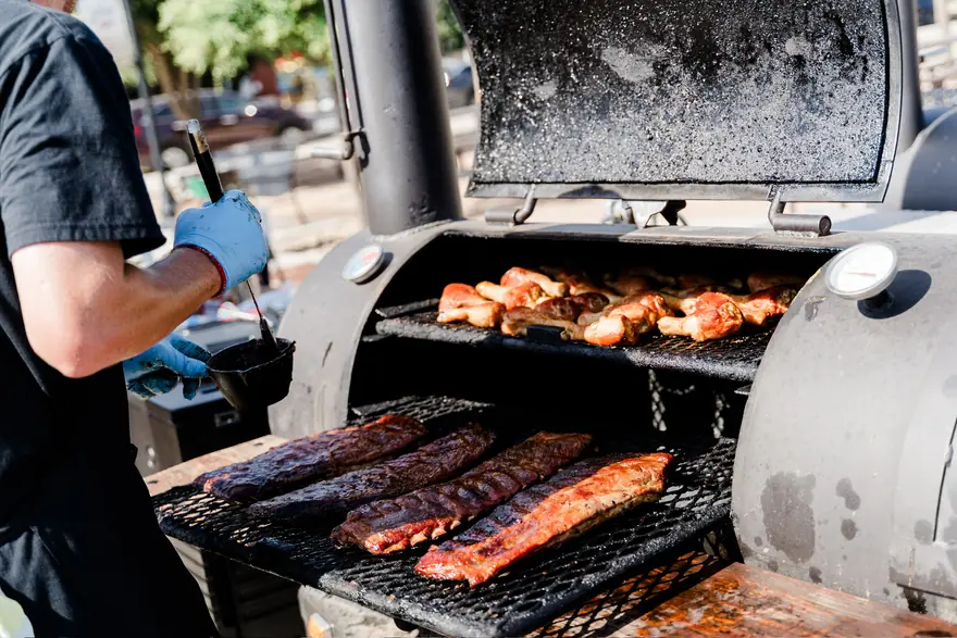 Sausage and ribs cooking over live fire on the grill