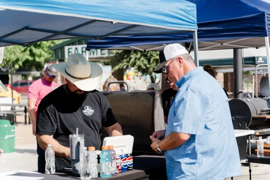 Two members of the Fire & Table crew serving guests from the tent