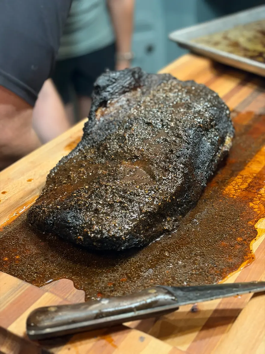 A whole smoked brisket resting on a cutting board
