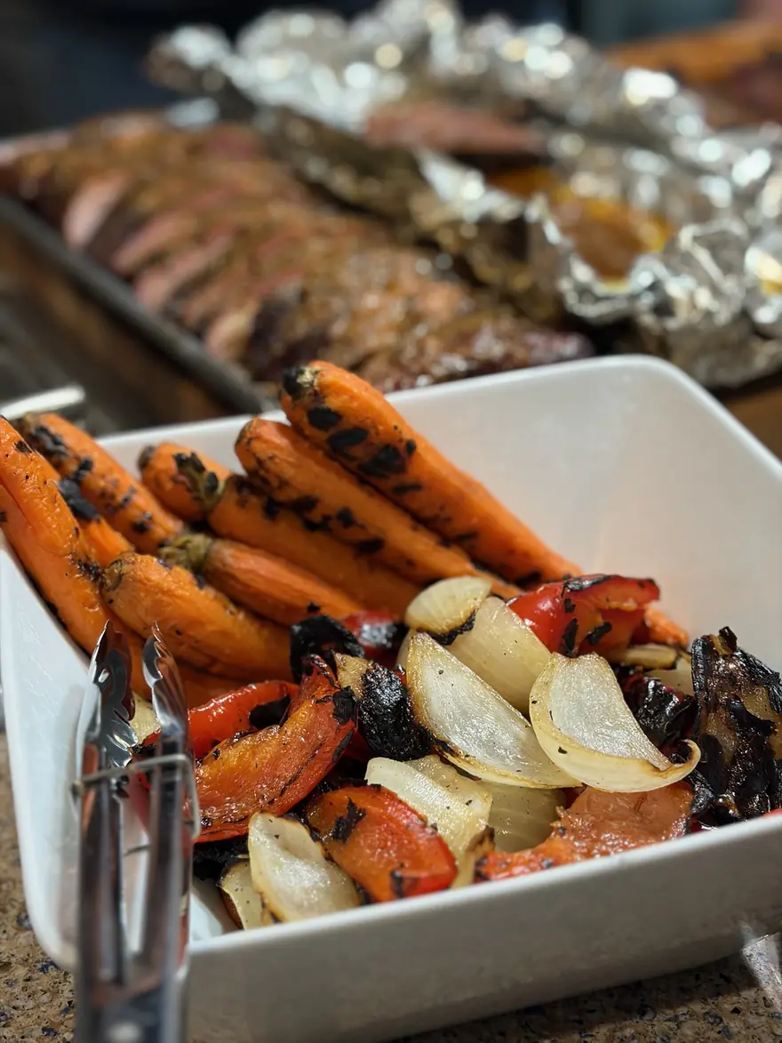 Fire-grilled carrots, peppers and onions in a serving dish